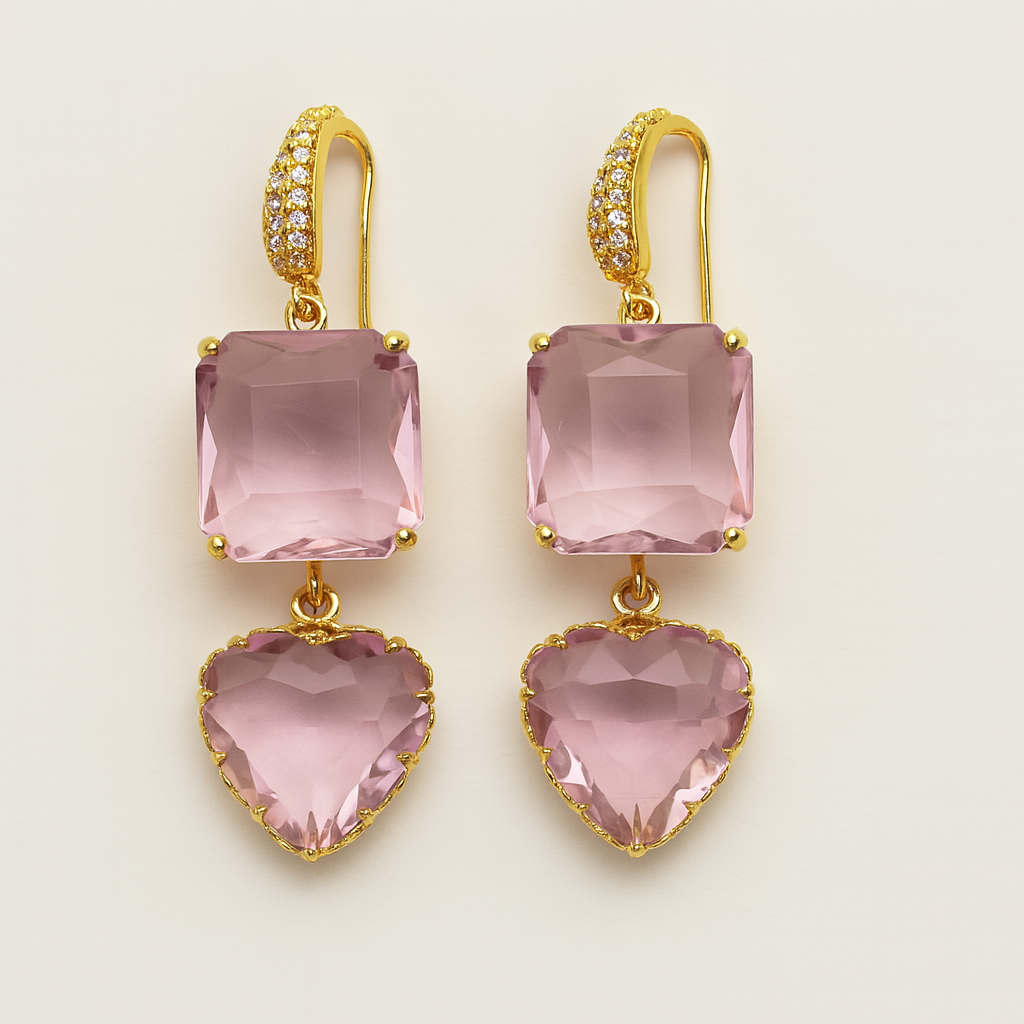 Gold earrings with pink heart and square stones on a beige background