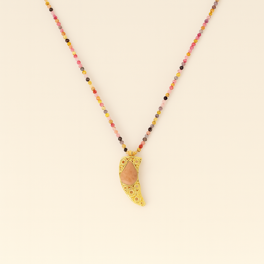 Necklace with colorful beads and a gold pendant on a beige background