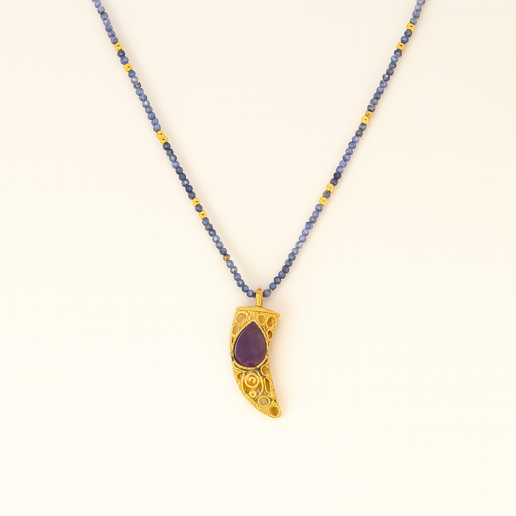 Necklace with a gold pendant featuring a purple stone on a white background