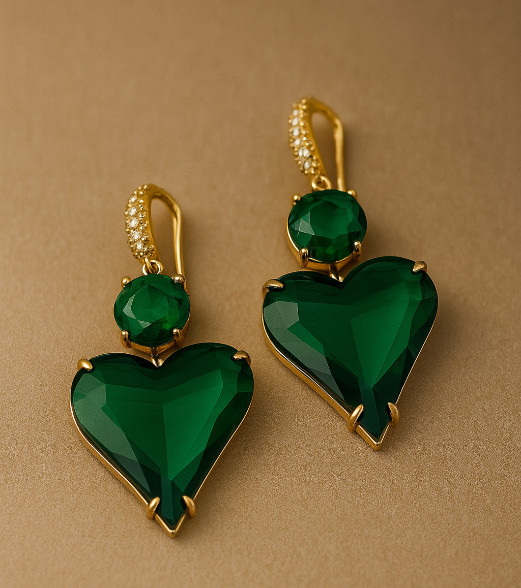 Green heart-shaped earrings with gold accents on a beige background