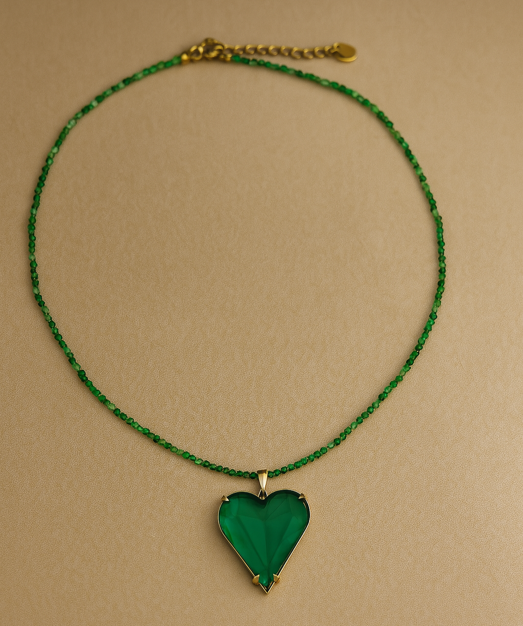 Necklace with a green heart pendant on a beige background