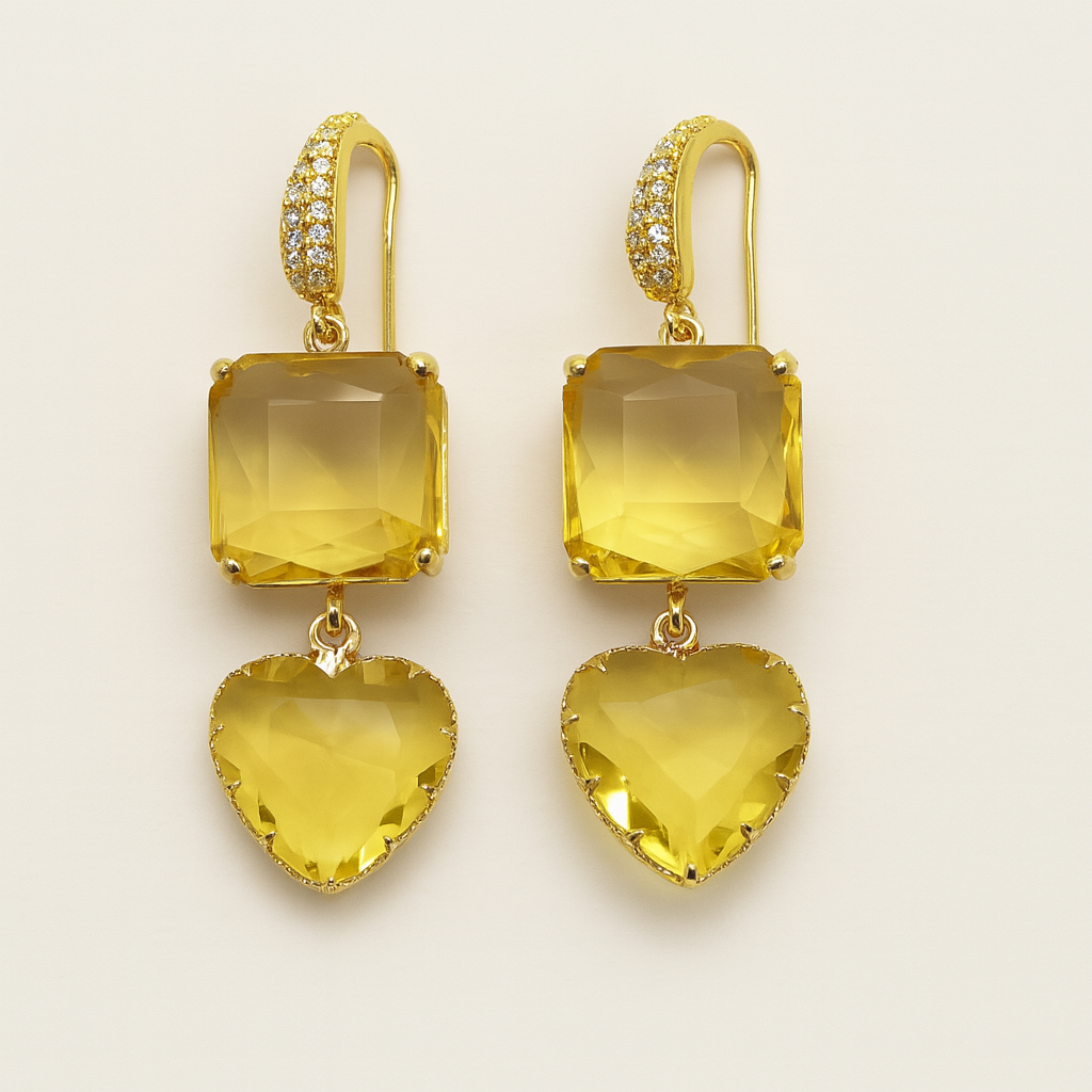 Gold earrings with yellow gemstones on a beige background