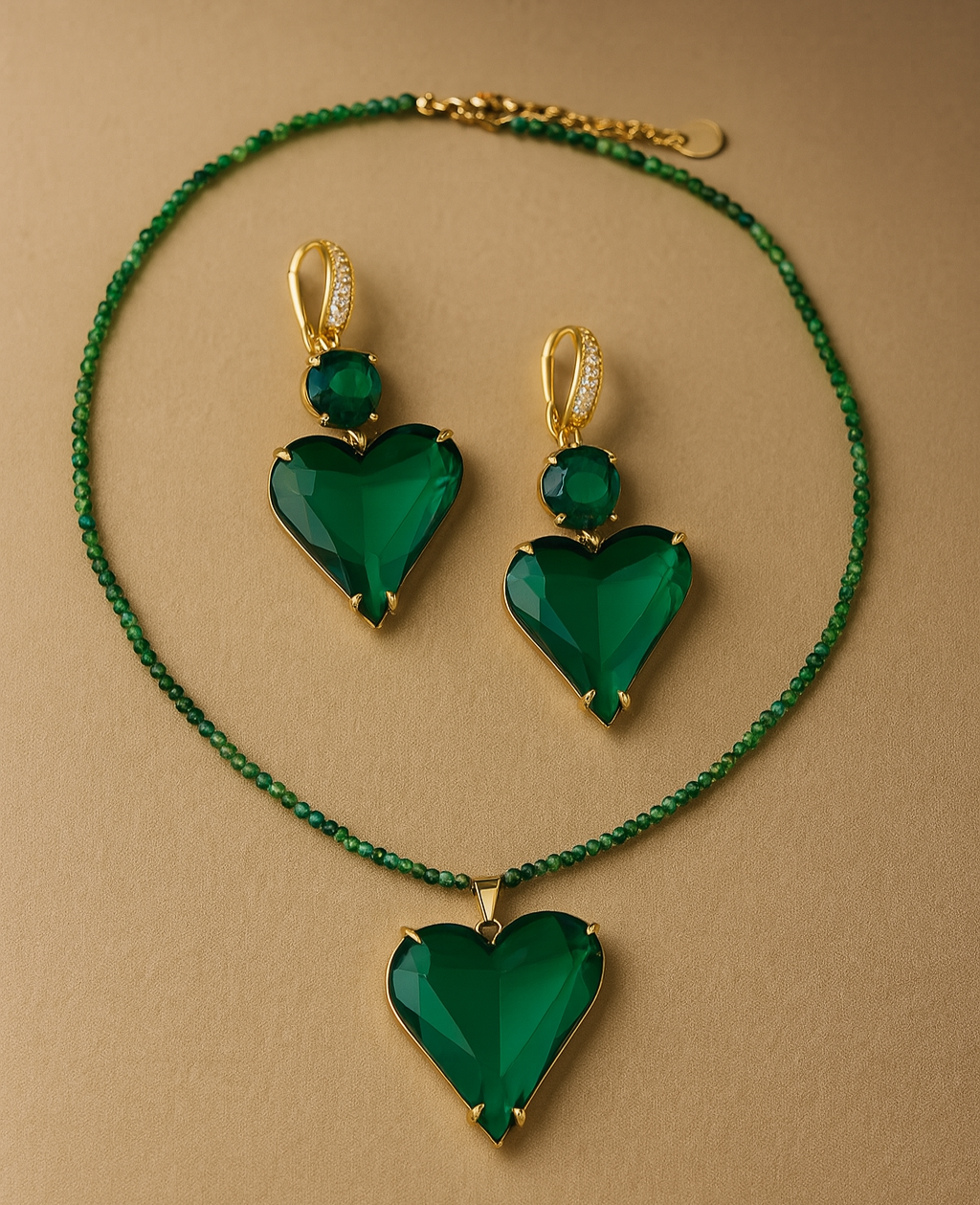 Green heart-shaped jewelry set with necklace and earrings on a beige background