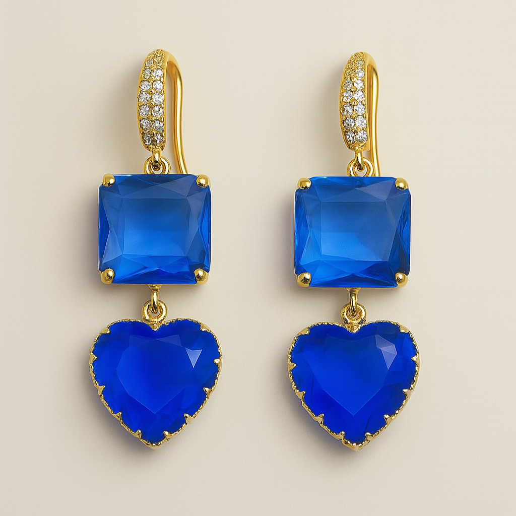 Pair of blue heart-shaped earrings with gold accents on a beige background