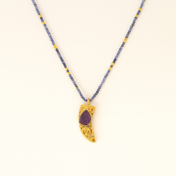 Necklace with a gold pendant featuring a purple stone on a white background