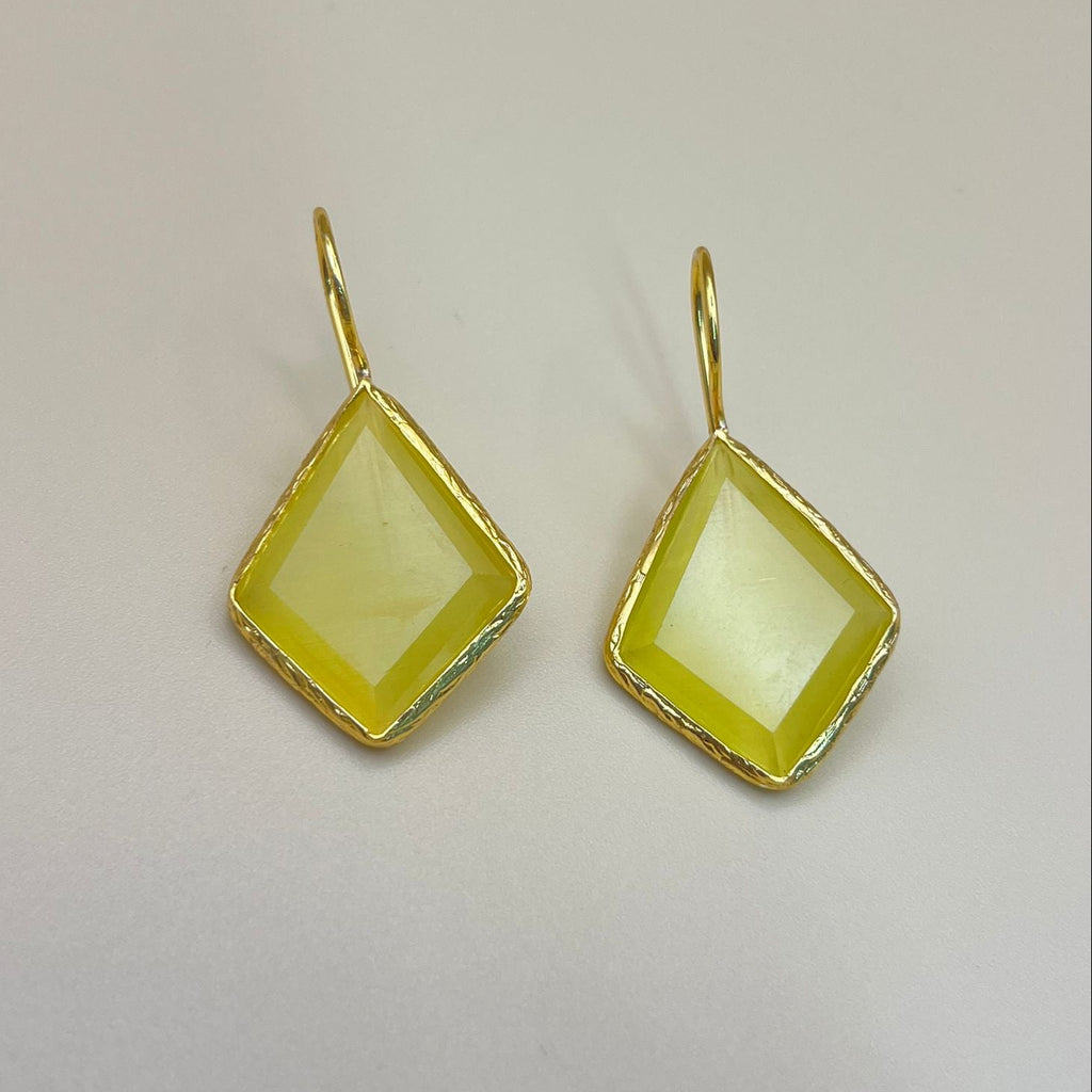 Gold-framed yellow gemstone earrings on a light gray background