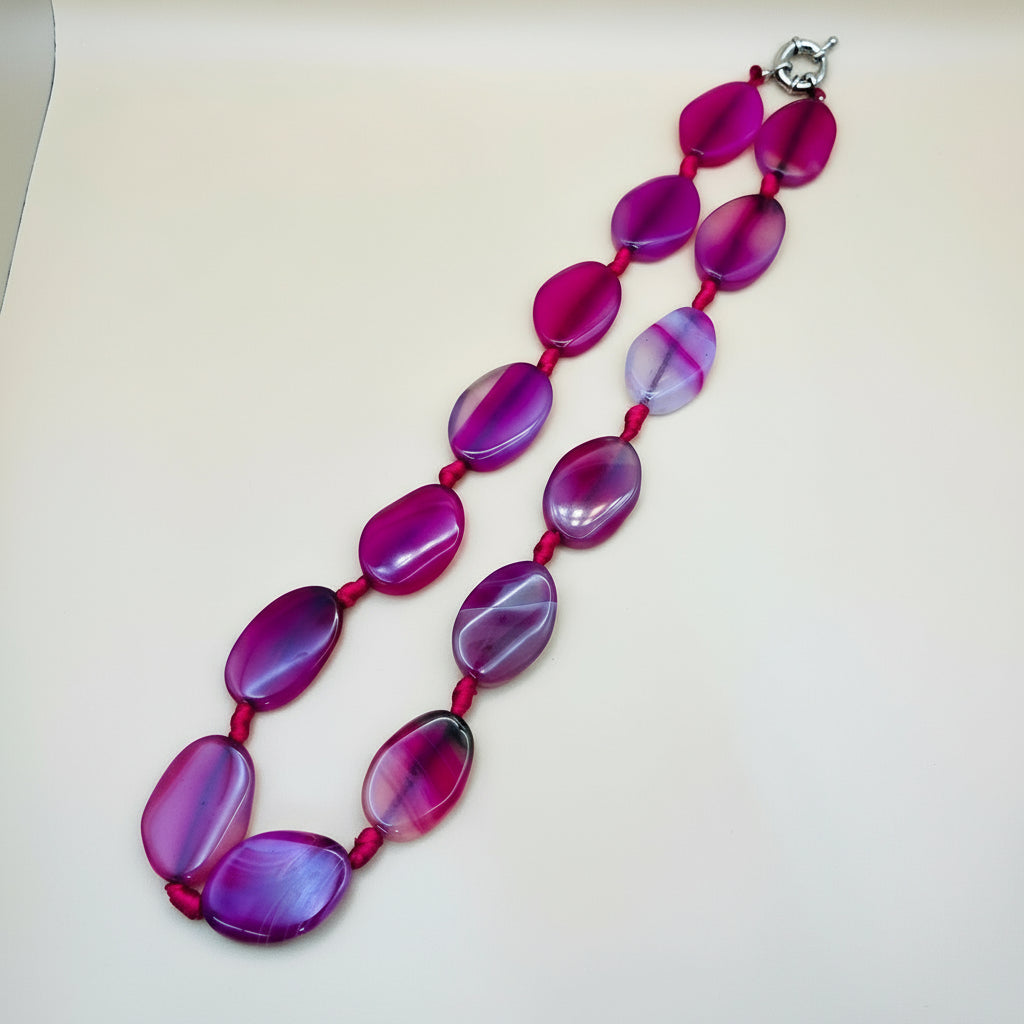 Necklace with pink and purple beads on a white background