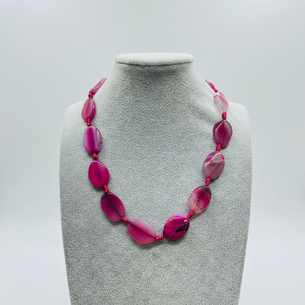 Pink beaded necklace on a mannequin bust in a store setting